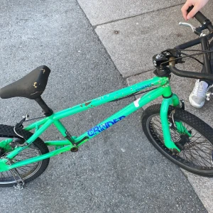 Grön BMX-cykel GRINDER kom och hämta den jag är lat den är helt ny köpte den i går har  - Säljer en grön BMX-cykel från GRINDER med svart sadel och svarta handtag. Cykeln har robust ram, grova däck och är perfekt för trix och skatepark. Sadeln är svart med slitna detaljer. Passar dig som gillar att cykla och göra tricks.