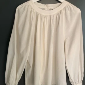 Vit tröja - Sparsamt använd. Knäpps med knappar baktill.