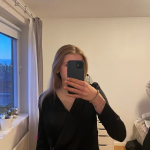 Svart topp från Bik Bok - Säljer en svart omlottopp från Bik Bok med lång ärm och v-ringning. Jättebra skick då den inte har kommit till användning. V-ringrningen sitter jättebra och är inte så slapp som den ser ut😊☺️