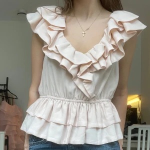 Söt volangtopp - Eftertraktad ljusrosa volangtopp från H&M🥰💕💕 Det står tyvärr ingen storlek men skulle säga att det är en M, dock passar den även mig som brukar ha XS/S🩷🌸