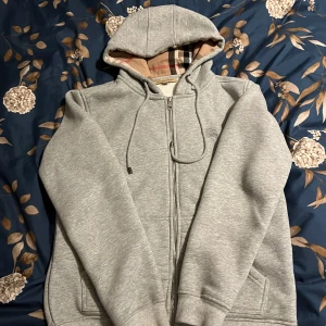 Burberry Zip - Säljer min frächa och snygga burberry zip hoodie. Perfekt nu för sommaren! Använd inte alls mycket och skicket är på topp. Storleken är S men passar utmärkt för XS. Priset kan diskuteras vid snabbköp😁