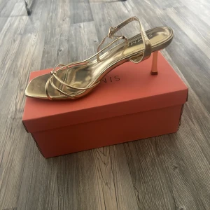 Guldiga klackar - Säljer ett par guldiga klackar från Asos. Säljer då jag även i dessa beställde två st. Perfekta för sommaren och superfina och även sköna🩷helt nya i förpackning.