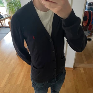 Ralph Lauren Cardigan  - Säljer en unik cardigan från Ralph Lauren i färgen mörkblå. Cardiganen är i relativt bra skick o har därav inga defekter. Hör gärna av er vid frågor eller funderingar!!!