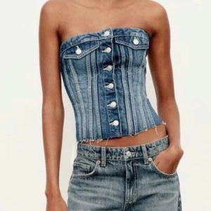 Jeans tubtopp med knappar - Säljer en snygg tubtopp i jeans med coola silverfärgade knappar framtill och rå kant nertill. ‼️den jag säljer är i en ljusblå (som är finare om ni frågar mig)‼️‼️ så klart kan vi diskutera priset