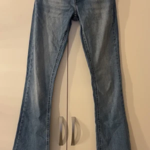 Bootcut jeans från ONLY, ljusblå XS - Ljusblå bootcut jeans från ONLY i storlek XS. Jeansen har råa, fransiga benslut och klassisk femficksdesign. Tillverkade i jeansmaterial med en snygg tvättad look. Perfekta för dig som gillar en avslappnad och trendig stil.