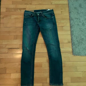 Dondup 33 - Säljer ett par blå dondup jeans i modellen george med feta slitningar. Byxorna har inga defekter alls och har sällan använts. Bara hör av dig om du undrar något!