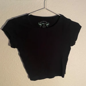 Svart croppad ribbad t-shirt - Säljer en svart croppad t-shirt med rund halsringning och korta ärmar. Toppen är ribbad och sitter tight mot kroppen, perfekt till många olika outfits.💞