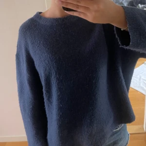Mörkblå stickad tröja - Mysig mörkblå stickad tröja med rund halsringning och långa ärmar. Tröjan har en enkel och stilren design, perfekt att matcha med jeans eller kjol. Materialet känns mjukt och ger en avslappnad look. Hör av er om ni har frågor eller vill ha fler bilder, priset går att diskutera💞tröjan är knappt använd!