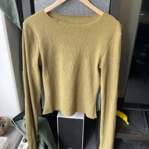 Topp sliten - Långärmad topp i slutet skick. Modellen är smal vid midjan så bra passform