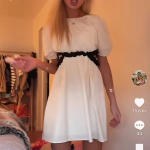 Vit klänning  - Söt vit kortklänning med puffärmar och svart vågig detalj i midjan. Endast använd en gång!!! Skriv för fler bilder!! Storlek 164 men passar xs-s