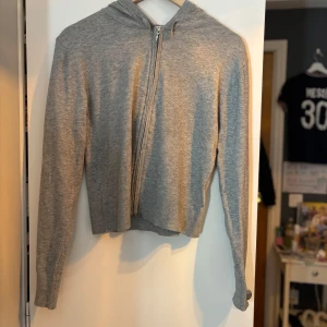 Grå stickad kofta  - Säljer en enkel och stilren grå hoodie från Gina Tricot i storlek 170. Tröjan har dragkedja framtill, huva med snörning och är långärmad den är knappt använd något utan nästan bara provad på så den är som ny