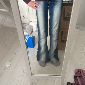 Blå bootcut jeans från Cheap Monday - Säljer ett par blå bootcut jeans från Cheap Monday med snyggt slitna detaljer och tydlig logga bak. Jeansen har hög midja och är tillverkade i klassiskt denimtyg. Perfekta för dig som gillar en retro vibe och vill sticka ut lite extra.Dom här är poppis nu så därför är priset lite högre ( skulle gärna villja byta dom mot ett par true religion jeans , men avslutar just nu med att sälja dom för håller på att sälja dom redan ) återkommer om det int hen vill ha byxorna 