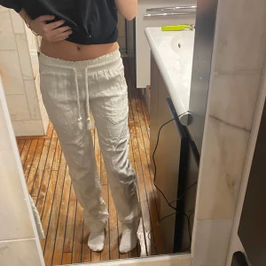 Vita linnebyxor  - Säljer ett par vita linnebyxor med avslappnad passform och dragsko i midjan. Byxorna har raka ben och är perfekta för en chill och bekväm stil. Superlätta och luftiga, passar perfekt till varmare dagar. Köptes för 800