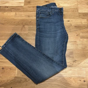 Blå jeans straight fit - Säljer ett par klassiska blå jeans från Jack & Jones med straight/slim fot och normal passform. Jeansen har fem fickor, dragkedja och knapp i midjan. Perfekta till vardags och lätta att matcha med olika stilar. Inga synliga slitningar eller detaljer.  