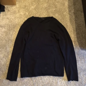 Svart alpackatröja från Daniele Fiesoli - Mörk, svart långärmad tröja från Daniele Fiesoli, tillverkad i mjuk alpackaull. Enkel och stilren design med rund halsringning. Perfekt för dig som gillar klassiska och bekväma plagg.