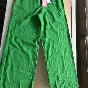 Gröna linnebyxor från JJXX - Säljer ett par gröna linnebyxor från JJXX i modellen MW Pant. Byxorna har rak passform och resår i midjan för extra komfort. Perfekta för dig som gillar en avslappnad och trendig stil.
