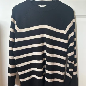 Svart och beige randig stickad tröja från Object - Säljer en svart stickad tröja från Object med beigea horisontella ränder. Tröjan har rund halsringning och långa ärmar. Perfekt för en avslappnad och stilren look.