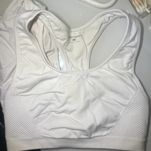 Vit sport-bh från Champion - Säljer 2 vit sport-bh från Champion med brottarrygg och ribbade partier på sidorna. Perfekt för träning och har en klassisk, enkel design utan mönster eller extra detaljer.