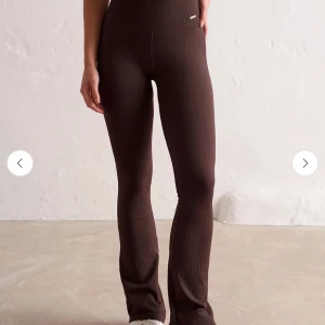 Bruna ribbade aimin tights  - Mörkbruna ribbade leggings med bootcut passform och hög midja. Byxorna sitter som en smäck, men har tyvärr aldrig använt de. Perfekta att styla med en crop top eller oversized hoodie.
