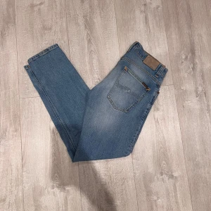 Nudie grim trim jeans - Säljer mina fräscha blåa nudie grim trim jeans. Dom är i storlek 32,32 och personen på bilden är 180 och väger 70kg. Mycket bra skick, säljer även fler jeans på min profil😃