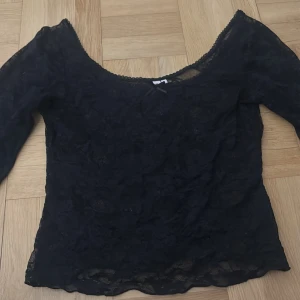 Svart spetsblus med djup urringning  - Säljer en svart blus i spets med djup urringning både fram och bak och har långa ärmar. Blusen är ganska tajt och liten i storlek (brukar ha 38/M i toppar och denna sitter tajt) 
