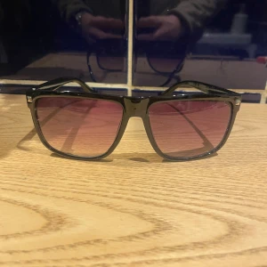 Ett par riktgt feta glajor  - Snygga solglasögon med svart, fyrkantig båge och röda tonade glas. Klassisk modell som passar till många stilar. 