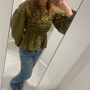 Gul och svart rutig blus med volangärm - Suuperfin blus i gult och svart rutigt mönster med långa ärmar och smockad överdel. Köp direkt för 250:- eller skriv privat och lägg eget bud🌸🌸