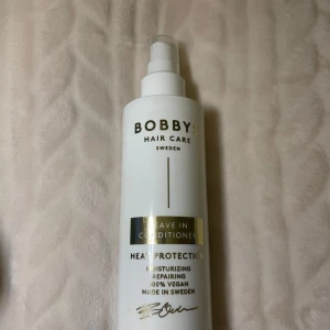 Bobby's Hair Care Leave In Conditioner Heat Protection - Leave in conditioner med värmeskydd från Bobby's Hair Care. Sprayflaska i vitt med svart och guld text. Produkten är återfuktande, reparerande och 100% vegansk. Tillverkad i Sverige.