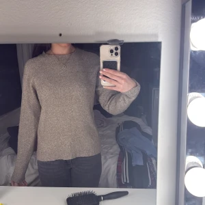 Beige stickad tröja - Säljer en enkel och stilren beige stickad tröja med rund halsringning. Tröjan har lång ärm och en rak passform som sitter bekvämt. Perfekt för lager-på-lager under kyligare dagar.