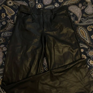 Svarta skinnbyxor från Zara - Snygga svarta skinnbyxor från Zara i storlek S. Byxorna har klassisk femficksdesign och raka ben. Perfekta för att lyfta vilken outfit som helst med en cool vibe. Midjan går upp till naveln, är 175 och dessa är lite för korta på mig. Jättesnyggt att styla med en stickad tröja! 🩷