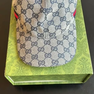 Gucci keps med monogrammönster - Snygg keps från Gucci i blått och grått med klassiskt GG-monogram över hela kepsen. Kepsen har böjd skärm och är tillverkad i bomullsmaterial. Perfekt accessoar för en trendig look.