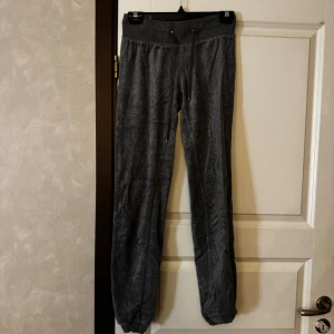 Mörkgrå mjukisbyxor med dragsko - Mysiga mörkgrå mjukisbyxor med resår och dragsko i midjan. Byxorna har raka ben och är tillverkade i ett mjukt material som passar perfekt för chill eller hemmadagar.