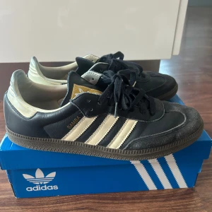 Adidas Samba sneakers marinblå/vit - Klassiska Adidas Samba sneakers i marinblå med vita ränder och detaljer. Skorna har snörning, platt sula och rund tå. Perfekta för dig som gillar retrostil och sportig look. Är storlek 44 men skulle säga att de passar 43 bättre. Säljer på grund av att dom är för små. Pris går att diskutera. Tar gärna emot byten i storlek 44-45