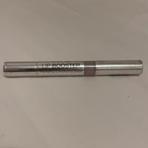 Lip Booster Plumping & Hydrating Gloss - Säljer ett Lip Booster plumping & hydrating gloss.  Med transparent sektion som visar en ljusrosa nyans. Perfekt för dig som vill ha fylligare och återfuktande läppar. Oöppnad har kvar plaster över. köpt för 145kr 