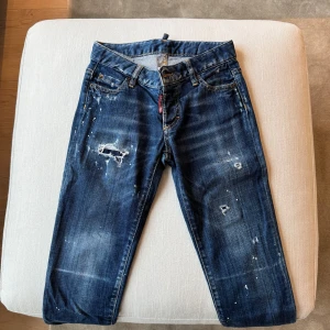 Dsquared2 jeans - Snygga blå jeans från Dsquared2 med slitningar och en broderad 'DD' detalj på bakfickan. Inköpta från Farfetch. Strl 34, med låg midja. Lite stora i strl. Fint skick, knappt använda. Pris kan diskuteras.