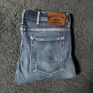 Replay hyperflex jeans - Snygga blå Replay Jondrill hyperflex jeans med en modern tvätt och slitna detaljer. De har en klassisk femficksdesign och en bekväm passform. Perfekta för en avslappnad stil.