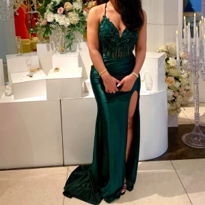 Grön långklänning med spetsdetaljer, snörning  - Elegant grön långklänning med vacker spets och pärldetaljer på överdelen. Klänningen har en slits och en figurnära passform. Passar både S/XS då den är justerbara med snören. Endast använd 2x. Klänningen är från SASHA.brudfest. 