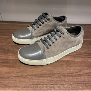 Grå sneakers från Lanvin - Snygga grå sneakers från Lanvin med en kombination av mocka och skinn. Använda men gott skick! 1500 inte lägre