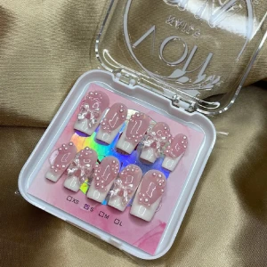 Rosa och vita lösnaglar med pärlor - Snygga lösnaglar i rosa och vitt med dekorativa pärlor och kristaller. Perfekt för en glamorös look. Kommer i en praktisk förpackning.