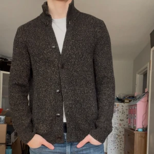 Stickad cardigan från ”banana republic” - En väldigt snygg och eftertraktad cardigan i snygg mörk färg. Den är ribbad och varm. 