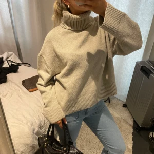 Beige stickad polotröja - Säljer en mysig beige stickad polotröja med ribbade detaljer vid krage och ärmslut. Perfekt för kyliga dagar och ger en stilren look🤎🤎 så snygg passform!!! 