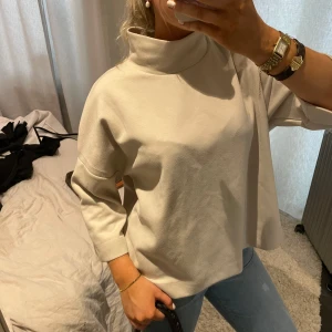 Beige polotröja - Säljer en stilren beige polotröja med trekvartsärmar. Tröjan har en lös passform och är perfekt för en avslappnad look. Den höga kragen ger en extra touch av elegans🤎🤎 super bra kvalitet!!! 