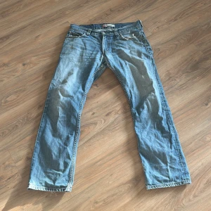 Levis 506 jeans - Säljer ett par klassiska Levis 506 jeans i ljusblå denim. De har en straight passform och är midwaist. Jeansen har en dragkedja och knappar framtill samt de ikoniska bakfickorna med Levis-märket. Perfekta för en avslappnad stil.