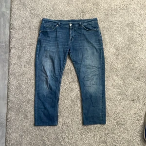 Blå jeans från dondup  - Snygga blå skinny fit jeans från dondup De har en klassisk femficksdesign och en knappgylf. Perfekta för en stilren look. Jeansen är i bra skick och de är proffesionellt uppsydda hos en skräddare. Vill bli av med de snabbt!!