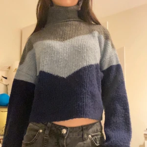 Flerfärgad stickad polotröja - Mysig flerfärgad stickad polotröja med blockmönster i blått, ljusblått och grått. 