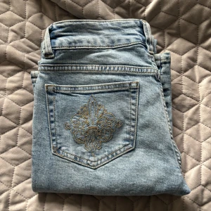 Ljusblå jeans med broderad bakficka - Sjukt snygga low waist bootcut jeans från lager 157 i storlek S full length. Rejält material och jättefina detaljer på fickorna. Endast använda 1 gång då de är lite för stora i midjan för mig. Slutsålda i nästan alla storlekar i de flesta butiker och  på hemsidan.