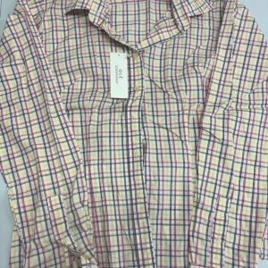 Rutig skjorta från Ole - Säljer en klassisk rutig skjorta från Ole i ljusa färger med inslag av rosa, blått och gult. Skjortan har långa ärmar och knappar framtill. Perfekt för en avslappnad stil.