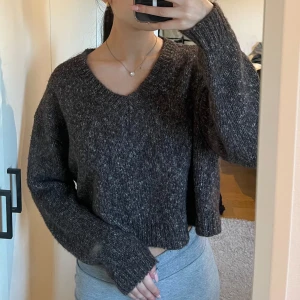 Brun stickad tröja från Zara - Säljer en mysig brun stickad tröja från Zara. Tröjan är croppad med långa ärmar och har en avslappnad passform. Perfekt för kyligare dagar eller sena sommarkvällar.