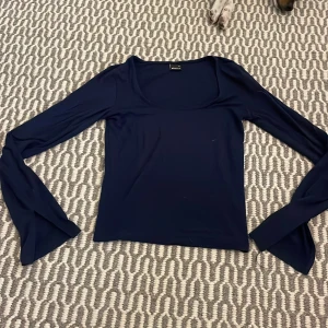 Mörkblå topp från Gina Tricot - Säljer en stilren mörkblå topp från Gina Tricot. Toppen har långa ärmar och en enkel design som passar perfekt till olika tillfällen. Materialet är mjukt och bekvämt.