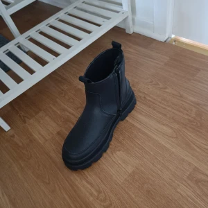 Svarta boots med dragkedja - Snygga svarta boots med dragkedja på sidan. Perfekta för en stilren look och passar bra till både jeans och kjol. De har en robust sula som ger bra grepp.